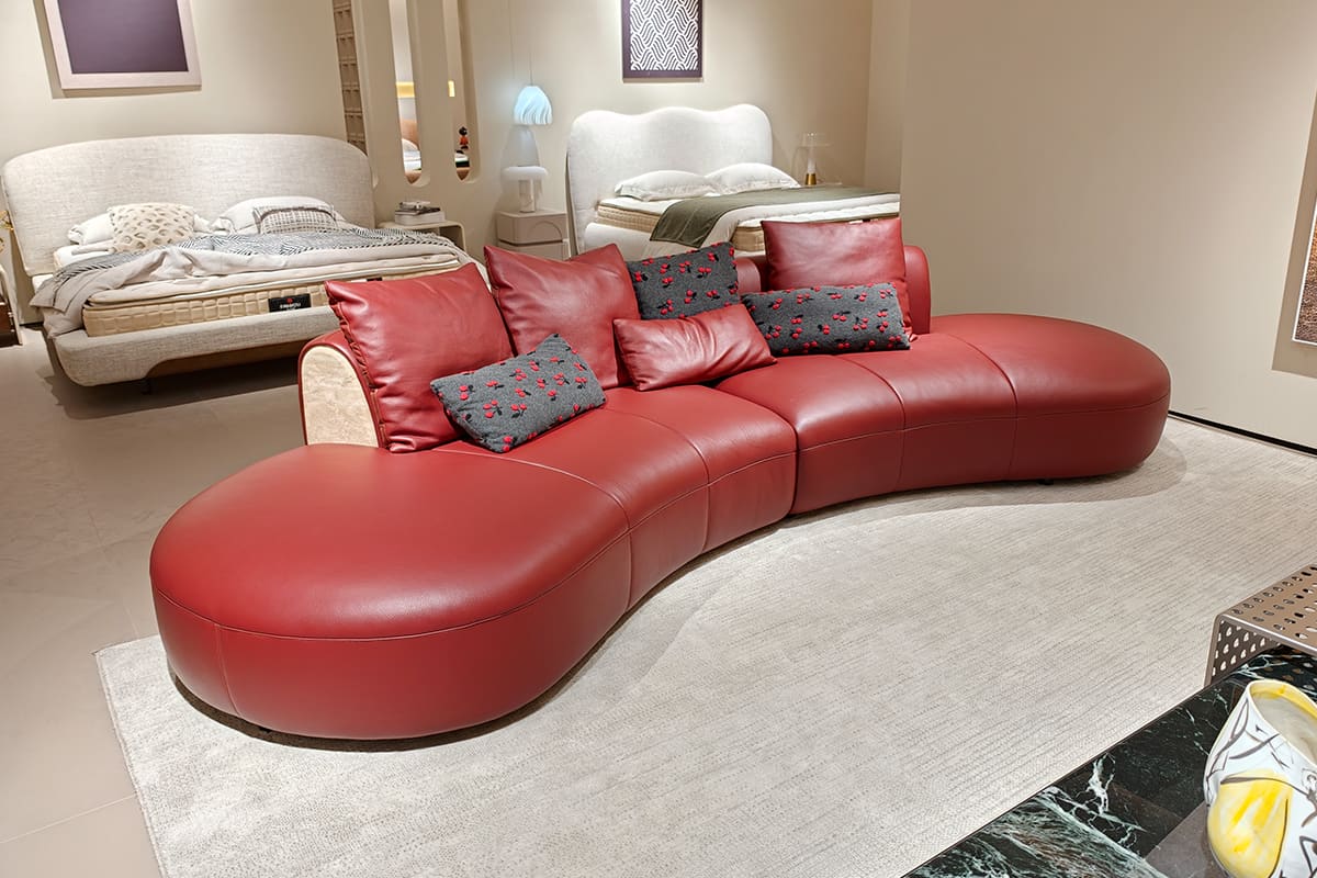 Curved leather sofa and upholstered beds in ATTICO CASA trade showroom
